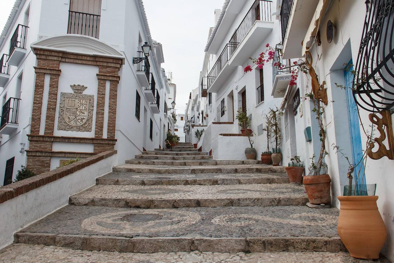 Sus calles peatonales, su estupendo empedrado en dos colores, formando dibujos geométricos y sus empinadas cuestas y escalinatas son el marco perfecto para las casas encaladas, de un blanco deslumbrante, llenas de tiendas de artesanía y recuerdos.