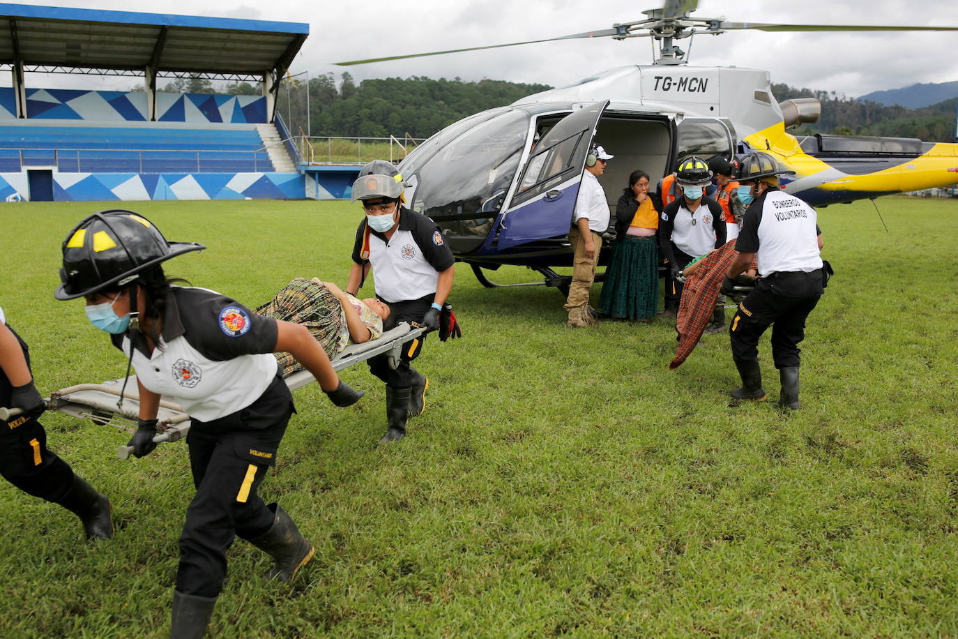 Las mujeres son ayudadas por rescatistas después de ser evacuadas de un área afectada por deslizamientos de tierra provocados por la tormenta Eta, en San Cristóbal Verapaz.