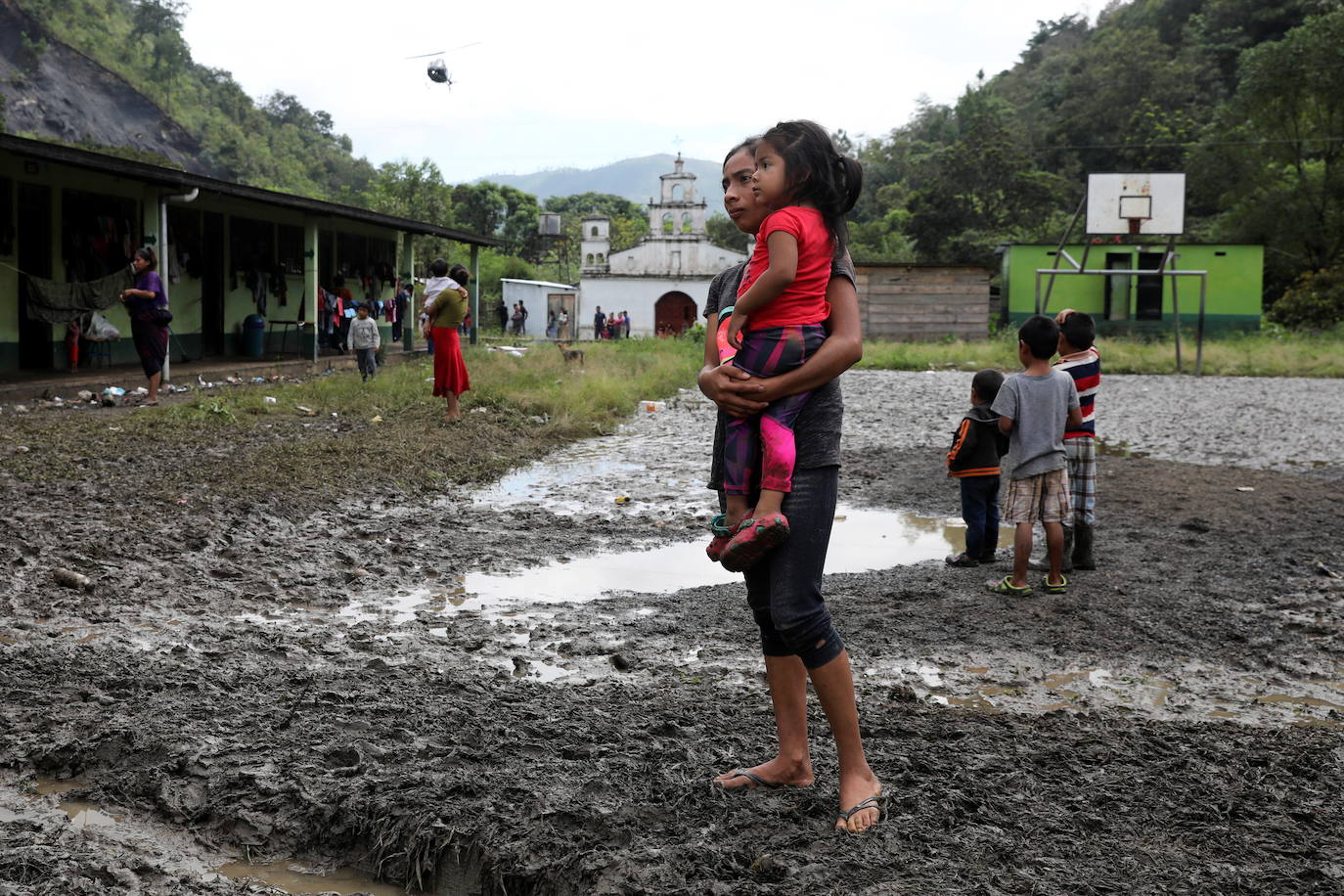 Una mujer y su hija esperan mercadería en una escuela, siendo utilizada como refugio temporal para personas de pueblos vecinos afectados por los deslizamientos de tierra provocados por las fuertes lluvias traídas por la tormenta Eta, en el pueblo de Santa Elena.