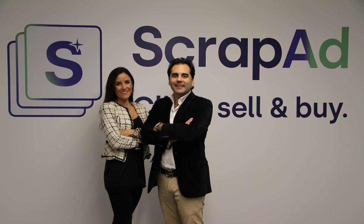 Sandra Montes y Samuel Ruiz posan ante el logo de su empresa.