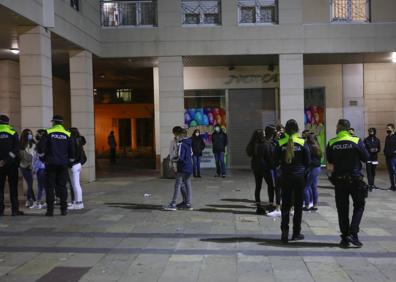 Imagen secundaria 1 - Jóvenes arremolinados en la plaza de Zumaia y presencia policial en este enclave. Abajo a la derecha, una estampida juvenil tras la aparición de efectivos de la Policía Local. 