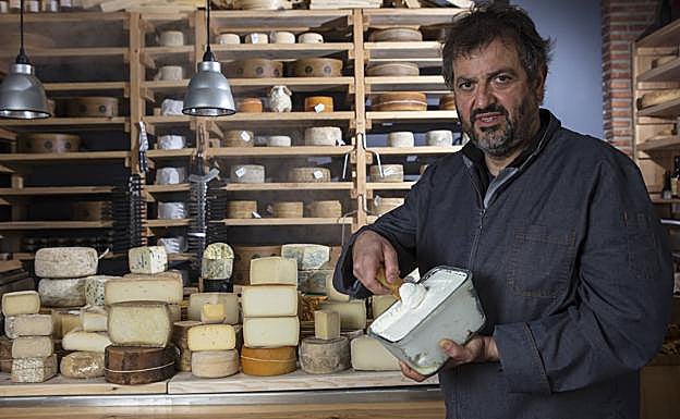 Andoni Vigalondo muestra su propio queso y la gran oferta de su tienda. 