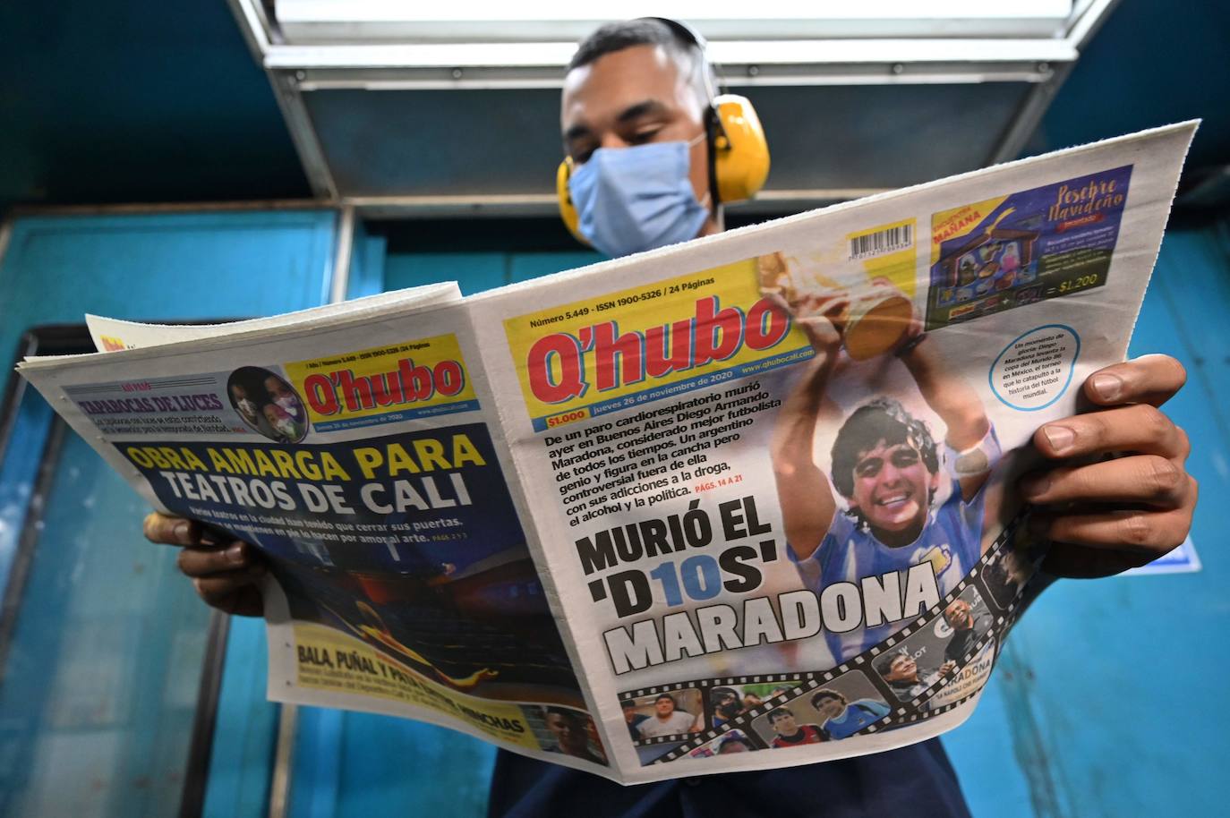 Un trabajador sostiene un periódico Q’hubo con una foto del fallecido leyenda del fútbol argentino Diego Maradona en la portada.