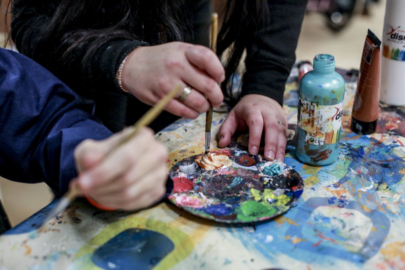 Usuarios y voluntarios participan en el taller de pintura de la asociación de parálisis cerebral Aspace, una de las numerosas actividades de las que disfrutan sus más de 130 miembros.