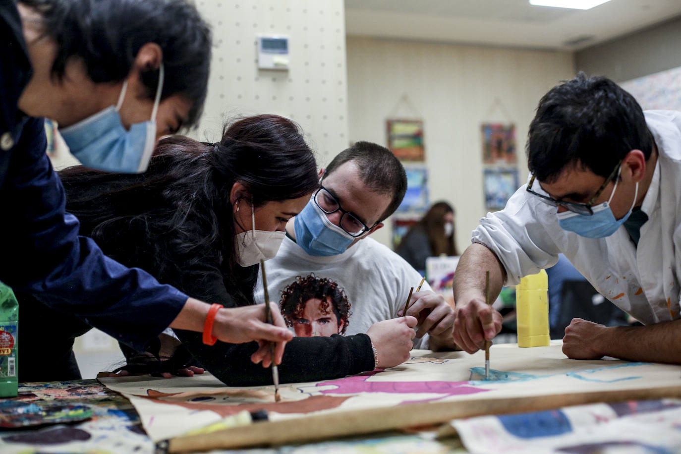 Usuarios y voluntarios participan en el taller de pintura de la asociación de parálisis cerebral Aspace, una de las numerosas actividades de las que disfrutan sus más de 130 miembros.