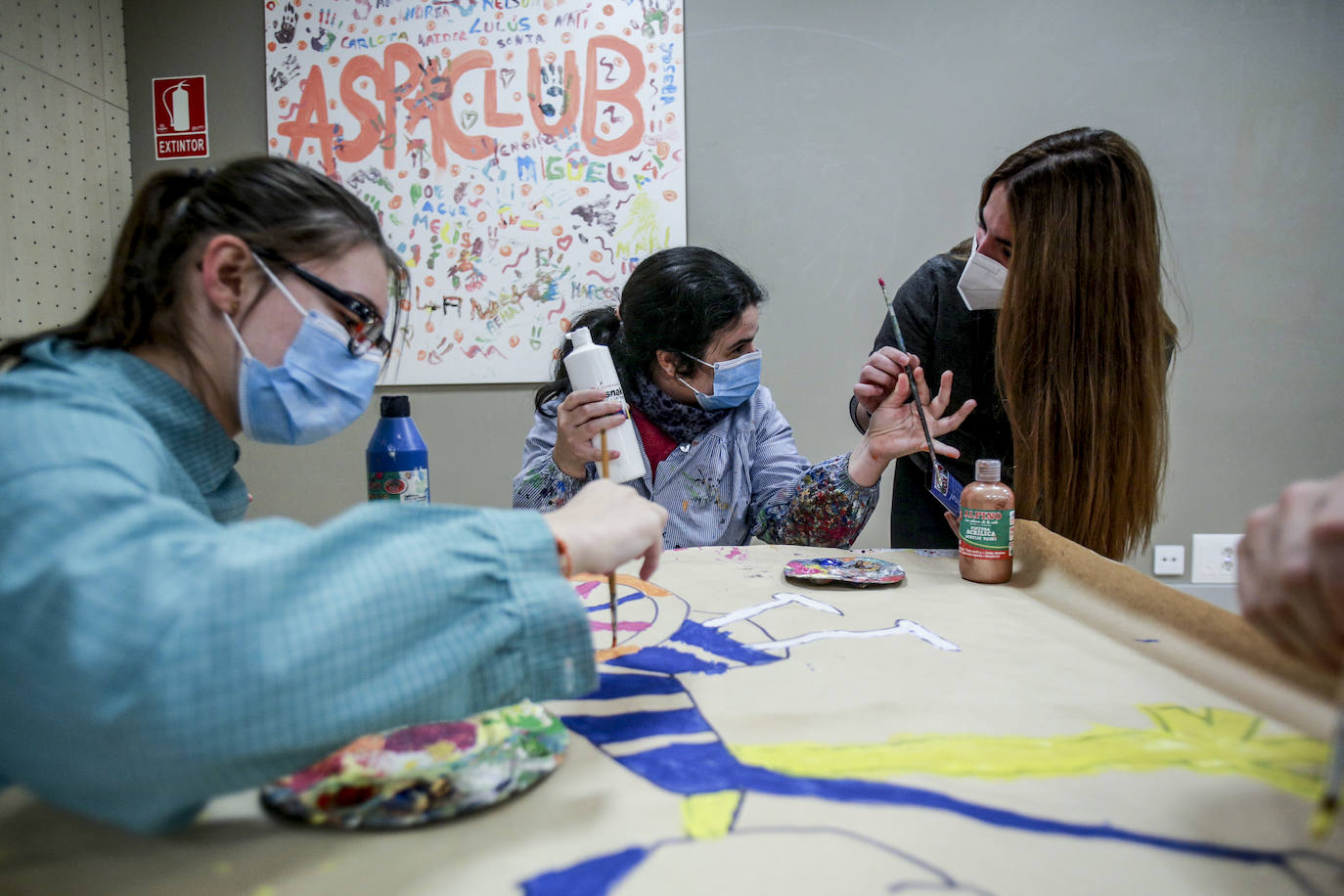 Usuarios y voluntarios participan en el taller de pintura de la asociación de parálisis cerebral Aspace, una de las numerosas actividades de las que disfrutan sus más de 130 miembros.