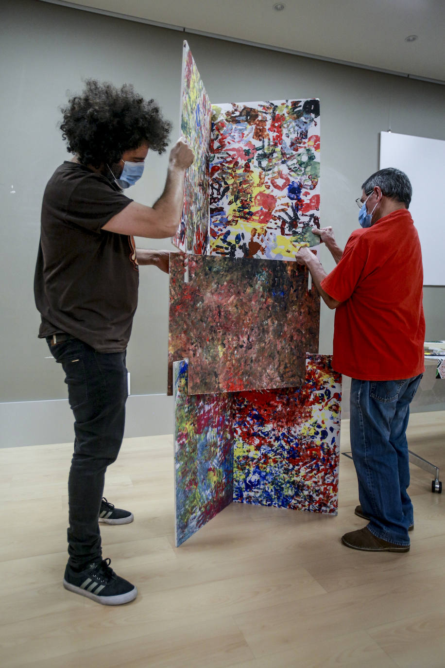 Usuarios y voluntarios participan en el taller de pintura de la asociación de parálisis cerebral Aspace, una de las numerosas actividades de las que disfrutan sus más de 130 miembros.