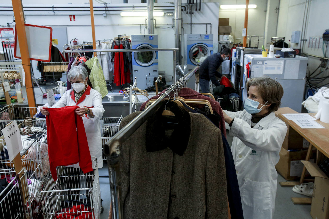 Voluntarias de Cáritas arreglan, lavan y preparan prendas recogidas en los contenedores que Koopera tiene repartidos por Vitoria para dejarlas listas para sus próximos dueños.