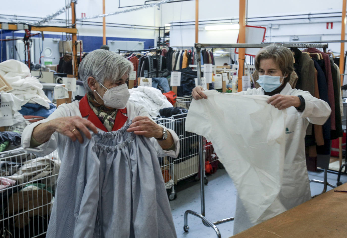 Voluntarias de Cáritas arreglan, lavan y preparan prendas recogidas en los contenedores que Koopera tiene repartidos por Vitoria para dejarlas listas para sus próximos dueños.