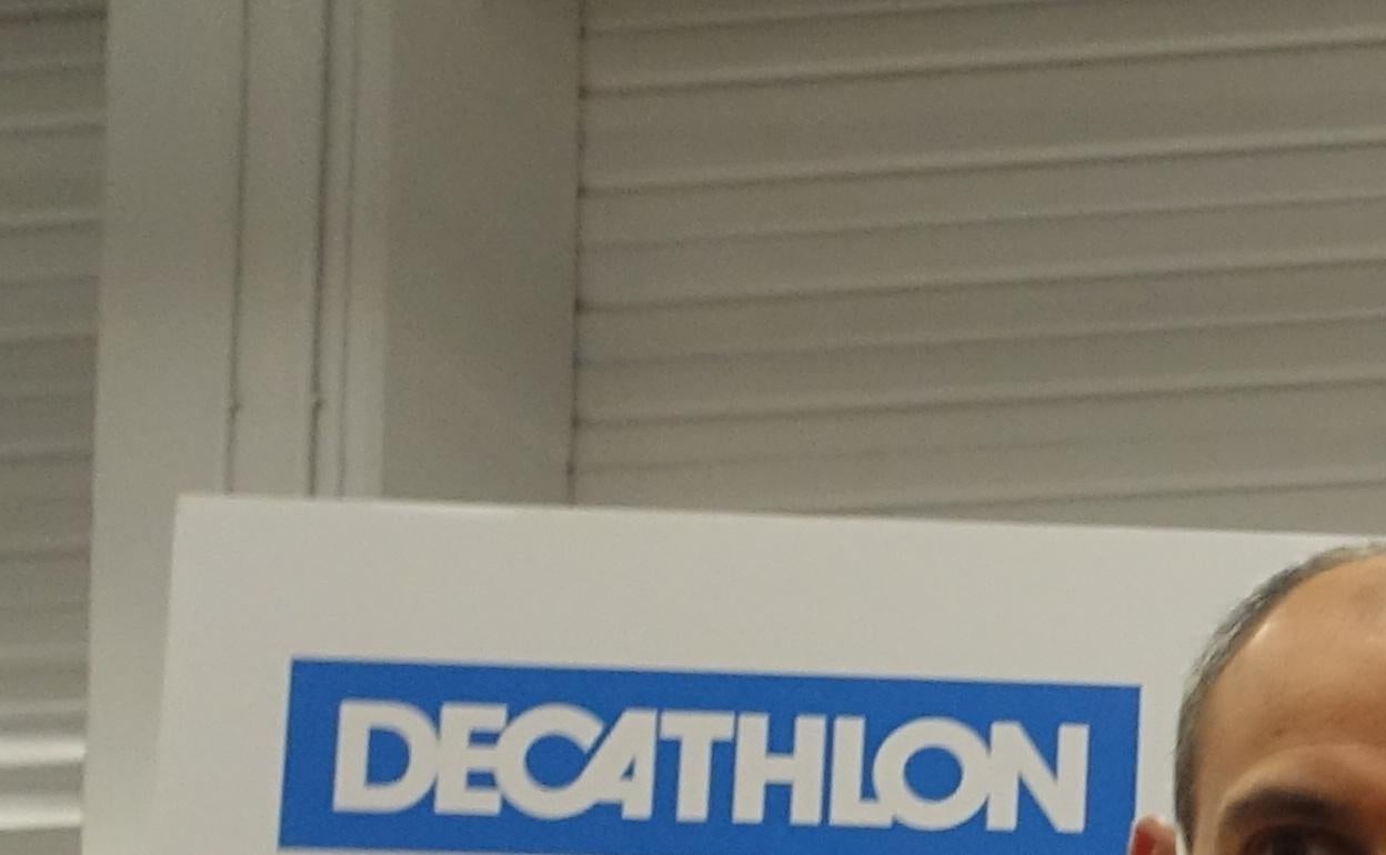 El responsable de Decathlon junto a Ane de Pablo y Omar Fraile tras estampar la firma 