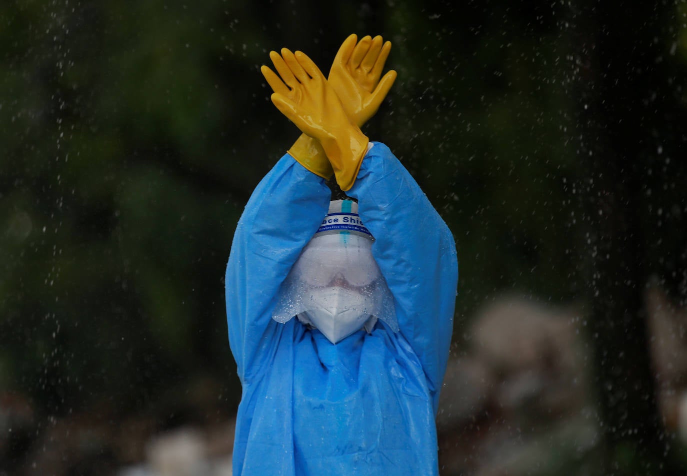 Una mujer soldado se desinfecta durante un entrenamiento sobre cómo manejar los cuerpos de las víctimas del coronavirus.