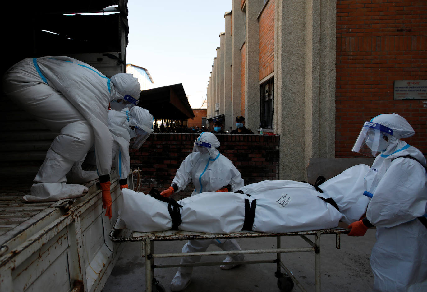 Mujeres soldados cargan el cuerpo de una víctima del coronavirus dentro de un camión antes de dirigirse hacia el crematorio en Katmandú.