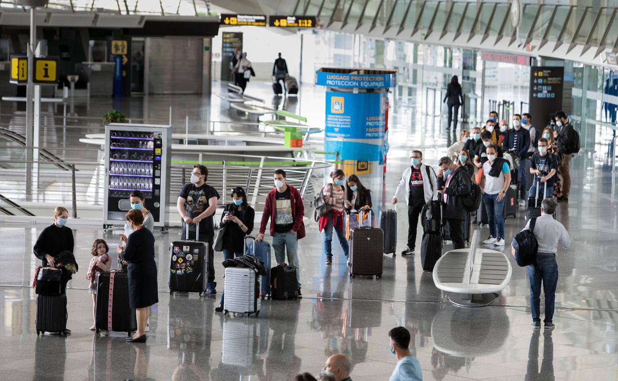 Cola de pasajeros esperan en el aeropuerto de Loiu.