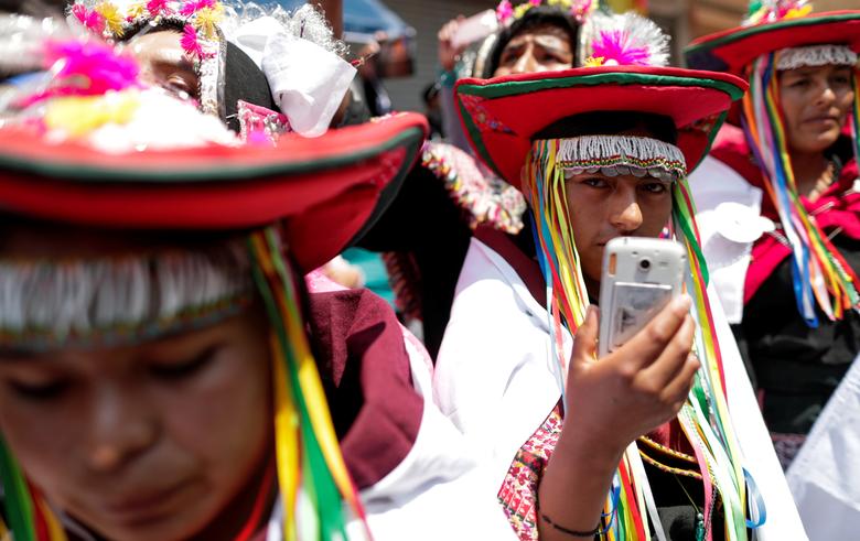 Bolivia. Un indígena sostiene un teléfono celular y mira mientras el ex presidente boliviano Evo Morales regresa a su país de origen desde el exilio en Argentina, en la ciudad fronteriza de Villazón.