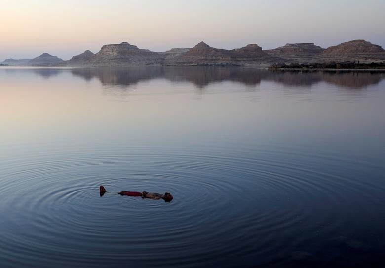 Egipto. Un egipcio nada en un lago frente al Taghaghien Island Resort en el desierto occidental de Egipto después de que el gobierno cancelara la celebración del festival de la paz de Siyaha.