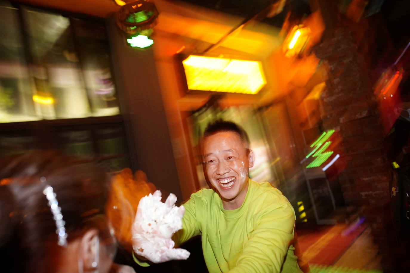 Un hombre se divierte con nata de un pastel de cumpleaños en una cervecería.