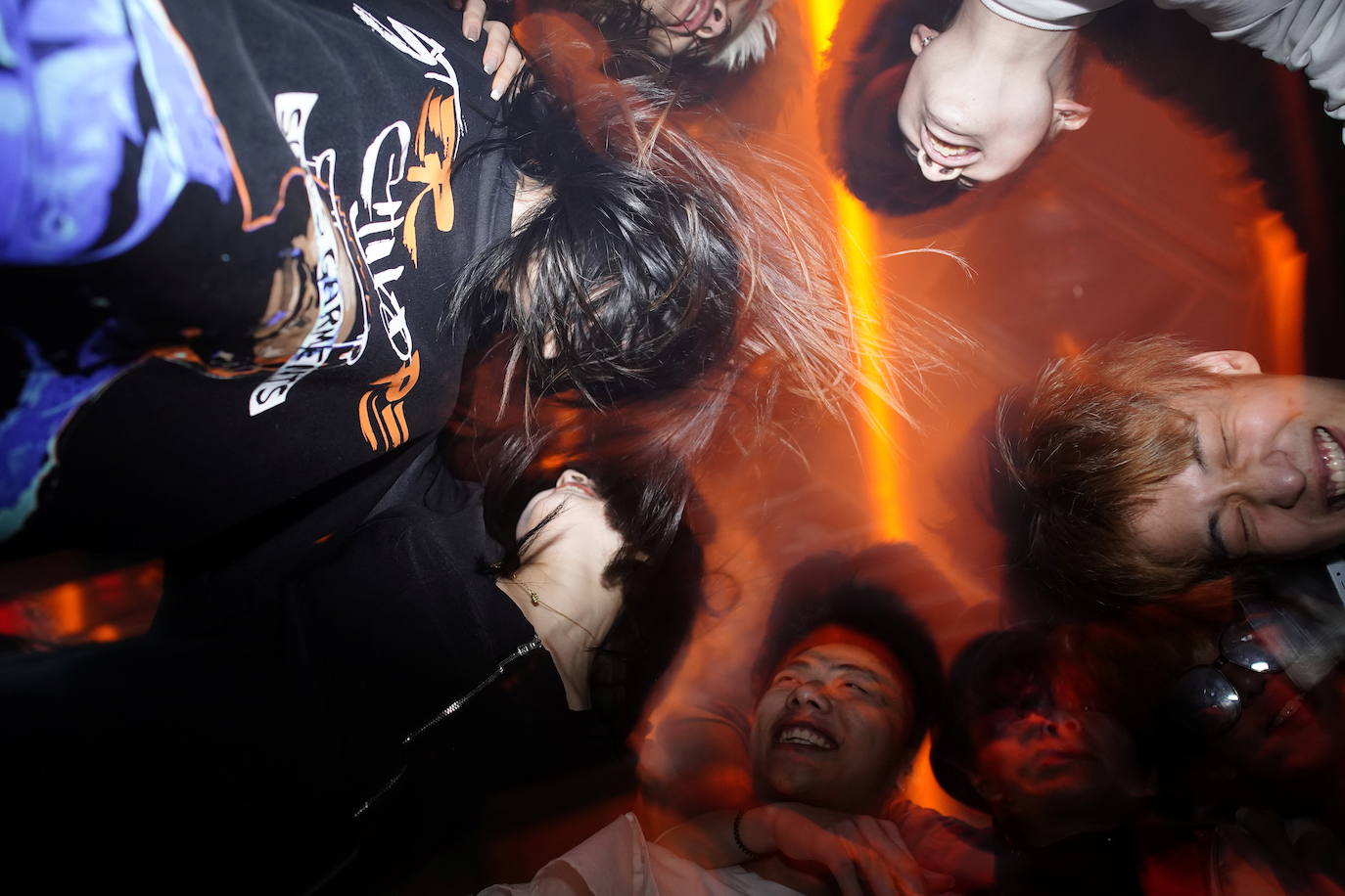 Jóvenes bailan en un club nocturno, casi un año después del brote global de la enfermedad por coronavirus.