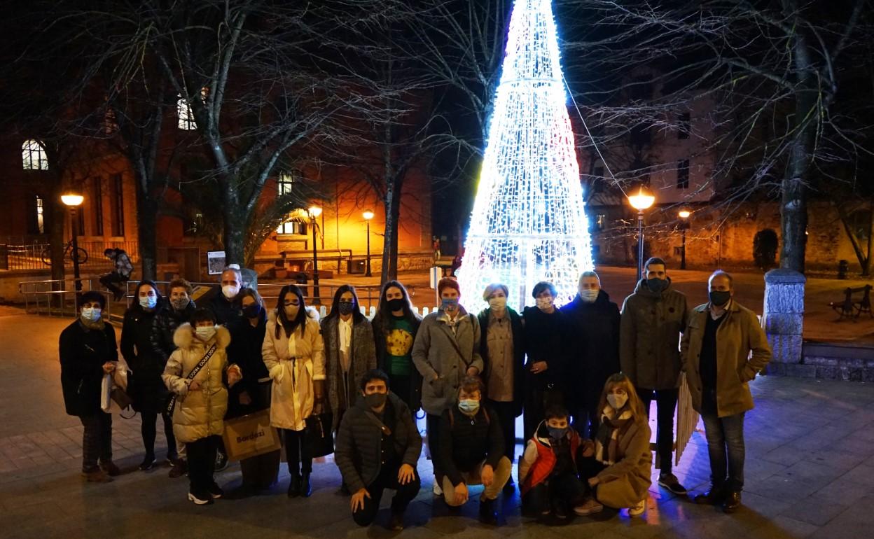 Integrantes de Dendak Bai posan junto a uno de los árboles LED que han instalado en la localidad para animar las fiestas. 