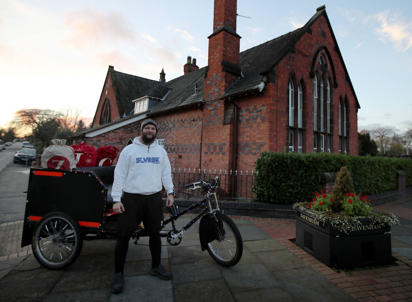 Paul Dean, un entrenador personal de Northwich se para junto a su bicicleta que usa para entregar regalos de navidad a las aldeas locales en Davenman, Gran Bretaña.