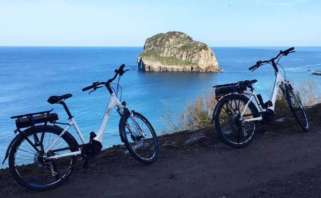 Bicis eléctricas frente al peñón de Aketxe, junto a Gaztelugatxe.