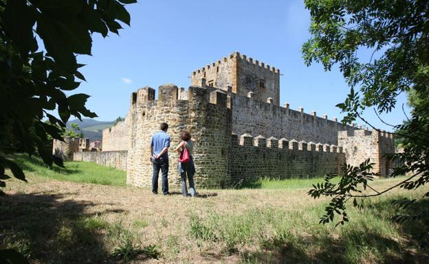 Una pareja observa las murallas del castillo de Muñatones. 