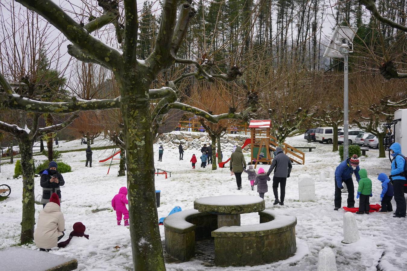 Niños y mayores juegan con la nieve en el puerto de Trabakua y en las cercanías del Oiz