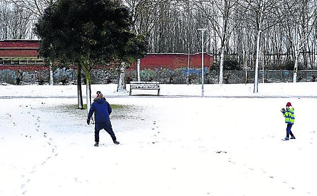 Un padre se lanza bolas con su hijo. 