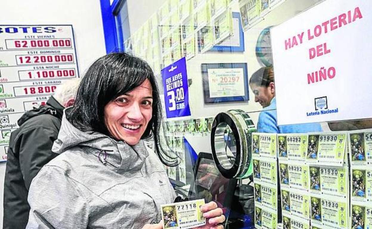 Una mujer compra lotería del sorteo del Niño 2020, en una administración de Vitoria. 