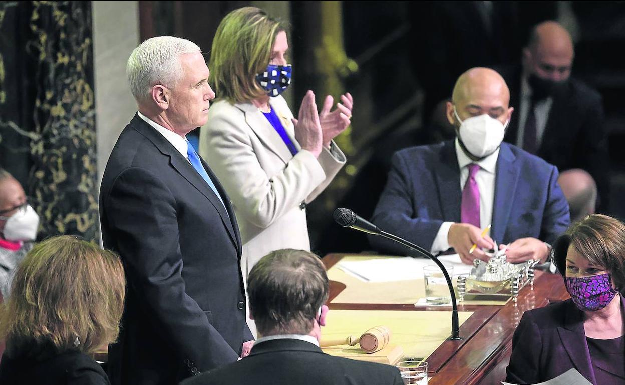 El vicepresidente Mike Pence, junto a la líder de la Cámara de Representantes, Nancy Pelosi, al reanudar la noche del miércoles la sesión tras el asalto al Capitolio. 