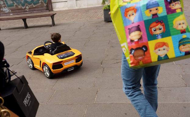 Un niño juega, junto a sus padres, con el coche que le han dejado Sus Majestades Los Reyes Magos, por una de las calles de Santa Cruz de Tenerife