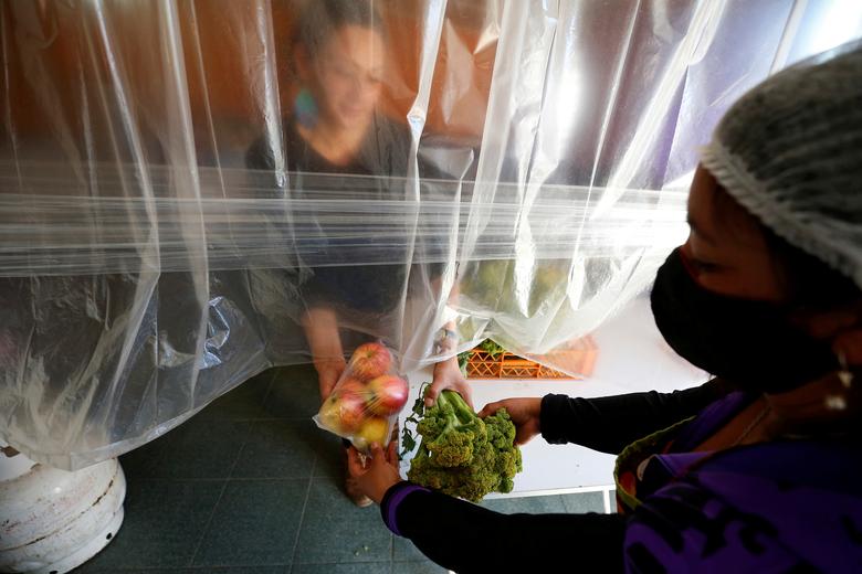 Un voluntario entrega raciones de comida en la llamada 'Olla común', una cocina comunal creada para proporcionar alimentos calientes a personas en riesgo de pobreza en Valparaíso, en Chile.