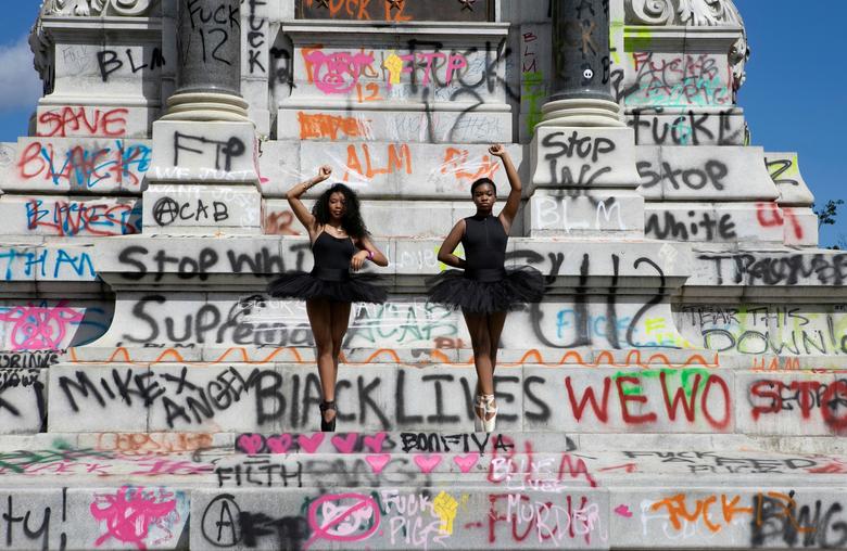 Las bailarinas Kennedy George, de 14 años, y Ava Holloway, de 14, posan frente a un monumento del general confederado Robert E. Lee después de que el gobernador de Virginia, Ralph Northam, ordenara su remoción después de disturbios civiles generalizados tras la muerte en Minneapolis bajo custodia policial de George Floyd, en Richmond. , Virginia, EE. UU.