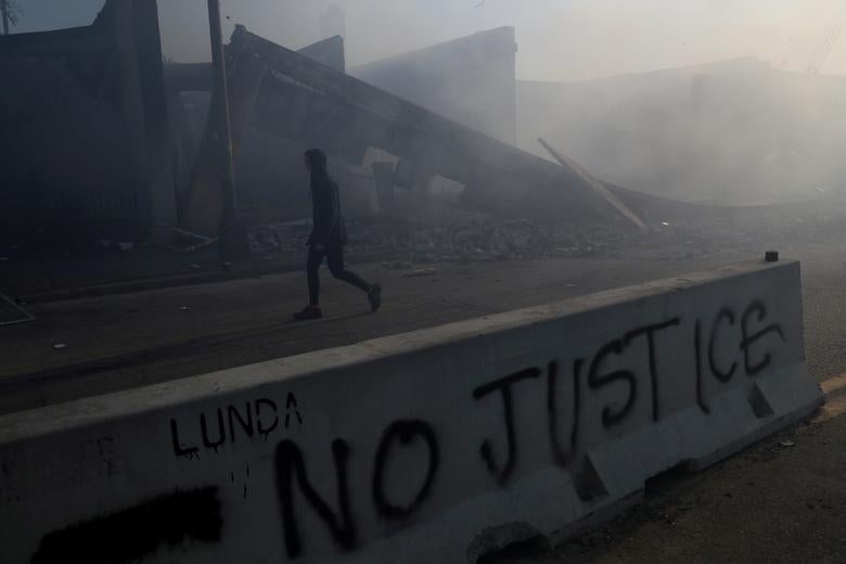 Los negocios dañados pueden verse después de otra noche de manifestaciones.