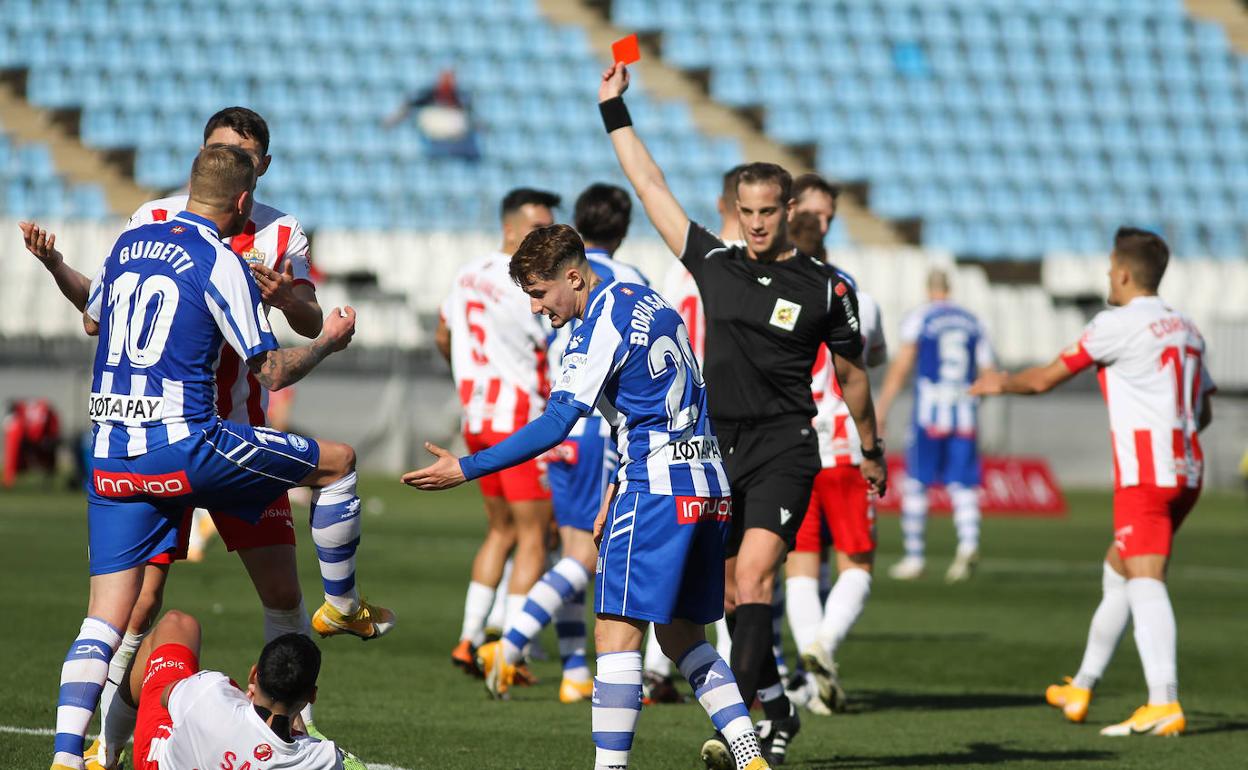 El colegiado muestra la tarjeta roja en el Almería-Alavés. 