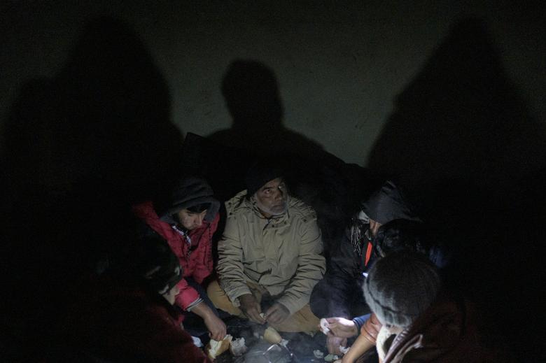 Los migrantes se calientan en una fábrica abandonada mientras cientos de ellos se refugian en edificios abandonados en la ciudad noroccidental de Bihac en Bosnia y Herzegovina.