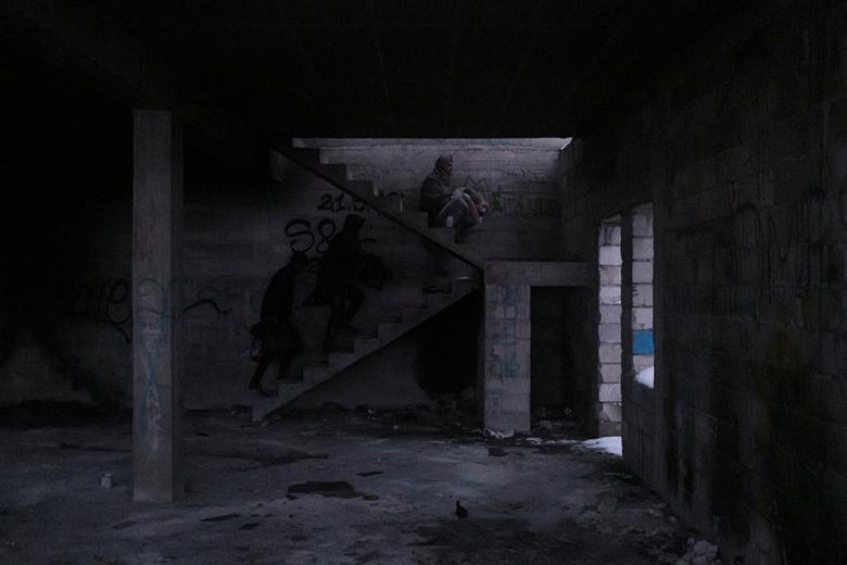 Migrantes caminan dentro de una casa abandonada. 