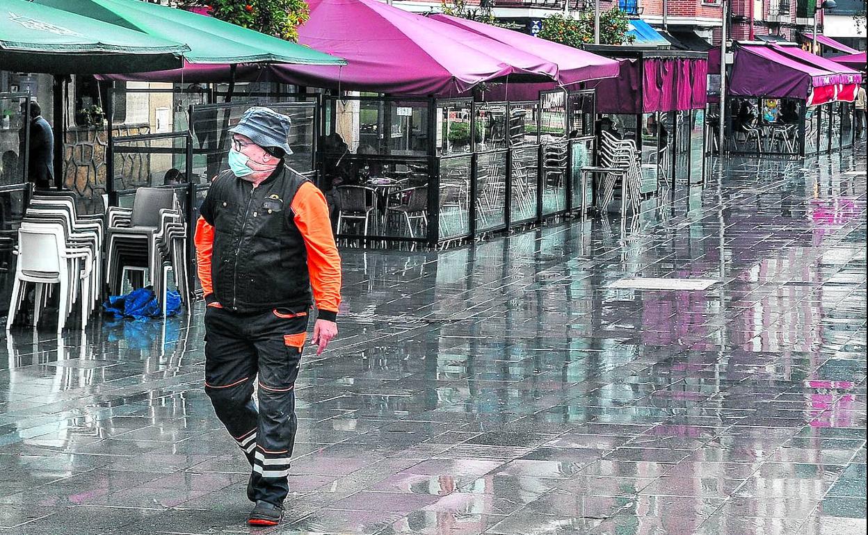 Un vecino pasa junto a las terrazas vacías junto a la plaza de Las Arenas, en Getxo. 