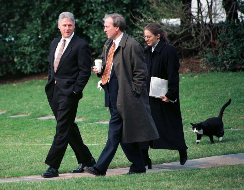 Socks el gato camina detrás del presidente Clinton, el secretario de prensa de la Casa Blanca Mike McCurry y la jefa de personal adjunta Sylvia Matthews, mientras cruzan el césped de la Casa Blanca el 6 de marzo de 1997 hacia el helicóptero Marine One antes de la partida de Clinton a Michigan.