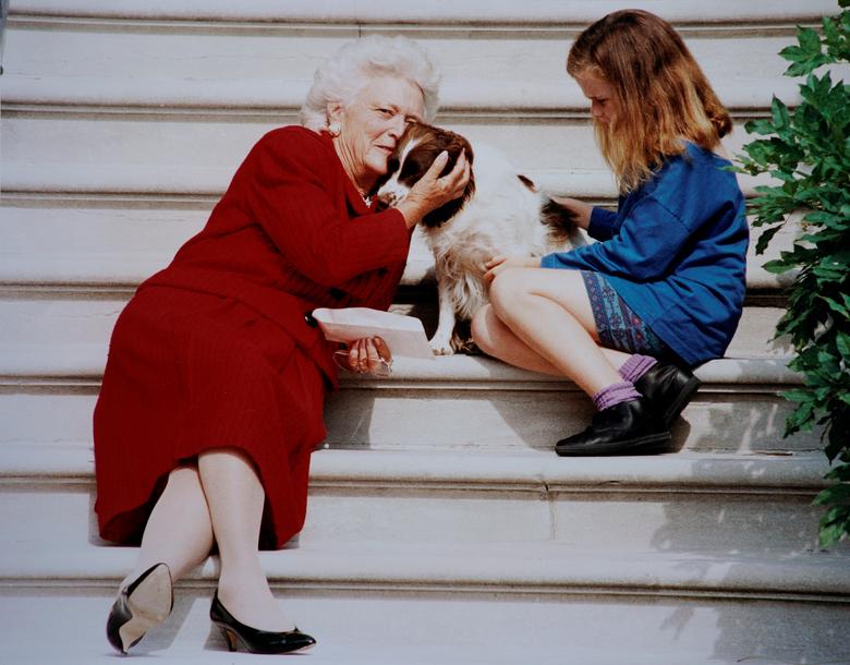 La primera dama Barbara Bush acaricia a su perro Millie mientras espera con su nieta Barbara a que el presidente George HW Bush llegue a los escalones de la Casa Blanca en esta foto sin fecha en Washington, DC.
