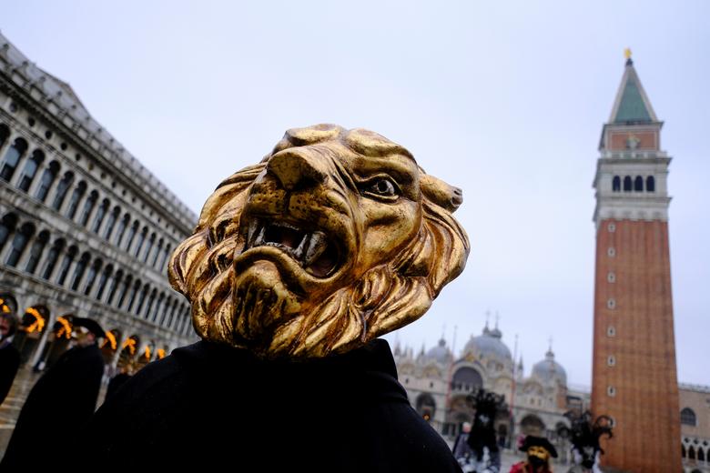 Un juerguista lleva una máscara de carnaval en la Plaza de San Marcos para celebrar el carnaval anual de Venecia.