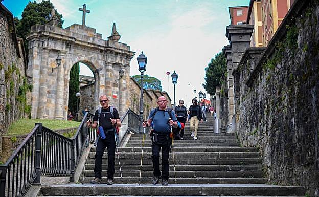 Dos peregrinos descienden de Begoña al Casco Viejo por las Calzadas de Mallona.