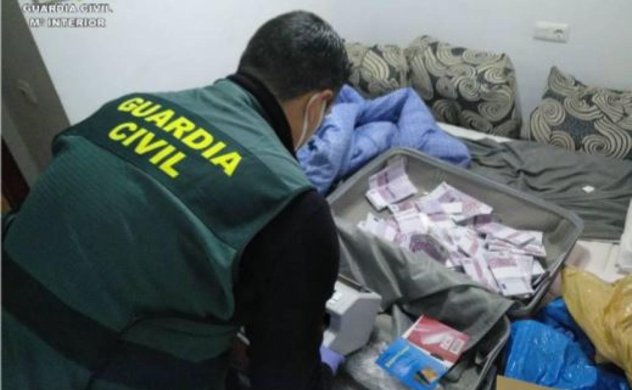 Un agente de la Guardia Civil confisca parte del dinero estafado. 