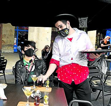 Un camarero atiende una terraza.