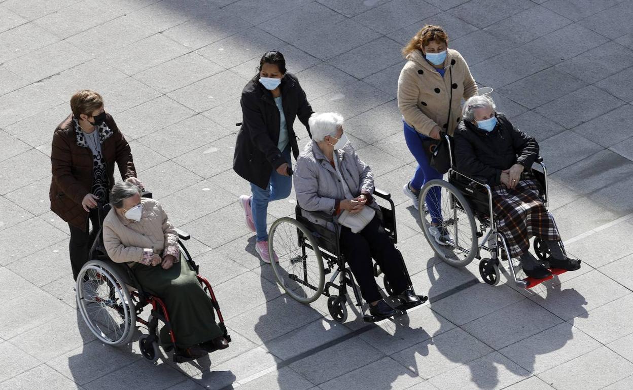 Tres mujeres dependientes pasean con sus tres cuidadoras en Bilbao. 