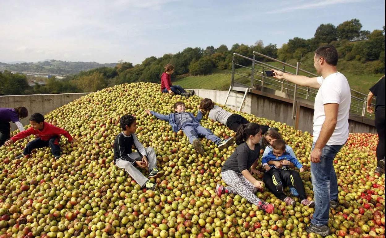 Un grupo de niños juega sobre las manzanas de la sidrería Petritegi, en Astigarraga.