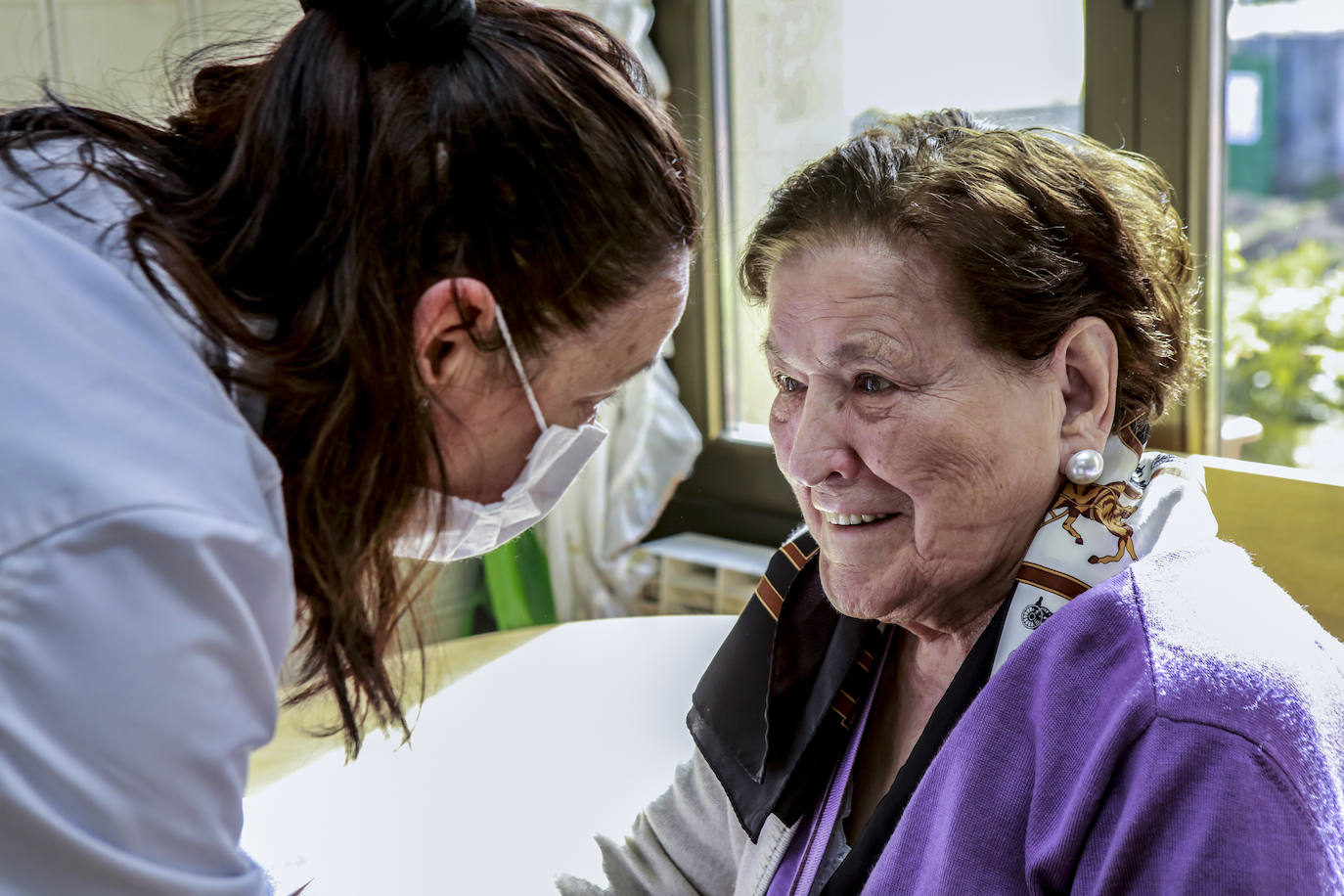 Margarita sonríe a Josete, su enfermera, tras haber sido vacunada. 