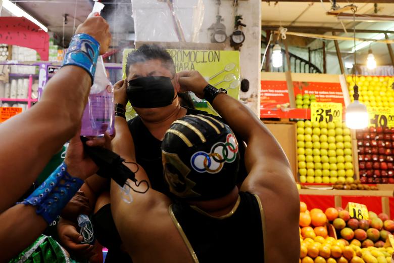 Luchador de lucha libre Guerrero Olimpico, alentar a los residentes sin máscara a usar máscarrillas.