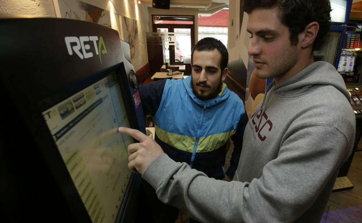 Dos jóvenes prueban suerte con las apuestas deportivas. 