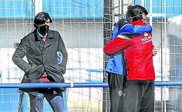 El abrazo de Joselu y un preparador, ante la mirada de Sergio Fernández. 