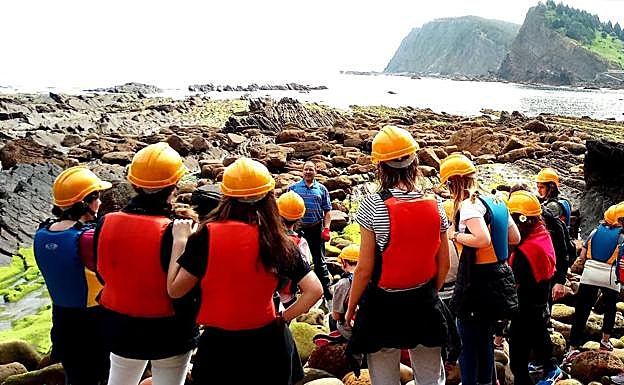 Un grupo de participantes en la ruta recorre el puerto de Armintza.